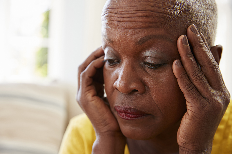 Senior Woman Sitting On Sofa At Home Suffering From Depression - JN Bank Safeguarding the finances of a loved one with Dementia