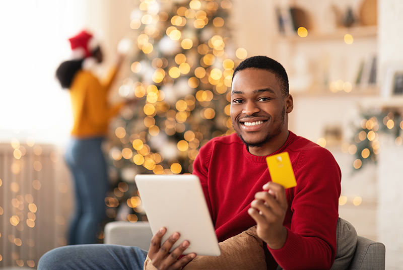 Young smiling african american husband hold tablet and credit card - JN Bank